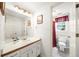 Well-lit bathroom featuring a large mirror, vanity with storage, and a separate toilet area at 815 Connell Ln, Lawrenceville, GA 30044