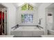 Vaulted bathroom with soaking tub and mosaic glass block window at 815 Connell Ln, Lawrenceville, GA 30044
