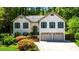 Charming two-story home with a two-car garage, shutters, landscaped yard, and set back in mature trees at 815 Connell Ln, Lawrenceville, GA 30044