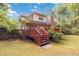 Brick home's backyard featuring a deck, brick chimney, and lush landscaping at 219 Garden W Walk, Hampton, GA 30228