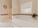 Clean bathroom with a garden tub, glass block window, and tiled floors at 219 Garden W Walk, Hampton, GA 30228