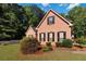 Well-maintained brick home with lush landscaping, green lawn, and black shutters on windows at 219 Garden W Walk, Hampton, GA 30228