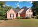 Lovely brick home with lush landscaping, manicured lawn, and charming windows with black shutters at 219 Garden W Walk, Hampton, GA 30228