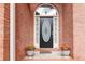Elegant front door with decorative glass insert flanked by planters with bright flowers at 219 Garden W Walk, Hampton, GA 30228