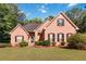Charming brick home featuring a well-manicured lawn and inviting curb appeal with classic shutters at 219 Garden W Walk, Hampton, GA 30228