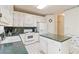 Traditional kitchen with white cabinetry, green countertops, and classic appliances at 219 Garden W Walk, Hampton, GA 30228