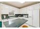 Well-lit kitchen featuring white cabinets, granite countertops, and modern appliances at 219 Garden W Walk, Hampton, GA 30228