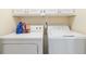 This laundry room features matching washer and dryer units under overhead cabinets at 219 Garden W Walk, Hampton, GA 30228