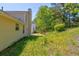 Side view of backyard featuring a vinyl-sided home with well-maintained lawn and mature trees for privacy at 6396 Phillips Ct, Lithonia, GA 30058