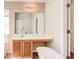 Bathroom vanity with wood cabinets, white sink, and large mirror, complemented by neutral wall colors at 6396 Phillips Ct, Lithonia, GA 30058