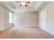 Spacious bedroom featuring a tray ceiling, ceiling fan, and natural light from the window at 6396 Phillips Ct, Lithonia, GA 30058