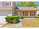 A front view of the home with attached garage, shrubbery, and front lawn at 6396 Phillips Ct, Lithonia, GA 30058