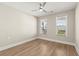 Bright bedroom with hardwood floors, ceiling fan and natural light from the two windows at 809 Kirby Dr, Woodstock, GA 30188