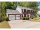 A charming two-story brick home features black shutters and an attached two-car garage at 850 Madison Chase Way, Lawrenceville, GA 30045