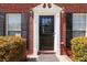 Close-up of the front door featuring a white trim, black door, and brick exterior at 850 Madison Chase Way, Lawrenceville, GA 30045