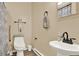 Bright bathroom features a pedestal sink, toilet, and a shower with a patterned curtain at 117 Manous Dr, Canton, GA 30115