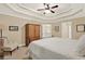 Primary bedroom featuring neutral walls, white trim, tray ceiling, ceiling fan and a stairway in the background at 117 Manous Dr, Canton, GA 30115