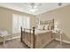 Bedroom featuring neutral colored walls, white trim, shutters, ceiling fan, and brass bed with a floral bedspread at 117 Manous Dr, Canton, GA 30115