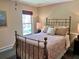 Charming bedroom with antique brass bed frame and cozy furnishings, providing a warm and inviting retreat at 117 Manous Dr, Canton, GA 30115