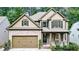 Charming two-story home with brick and siding exterior, two-car garage, covered porch, and professionally landscaped front yard at 117 Manous Dr, Canton, GA 30115