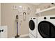 A laundry room with front loading washer and dryer and white cabinets at 117 Manous Dr, Canton, GA 30115