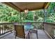 A covered porch with outdoor seating surrounded by lush greenery and trees at 117 Manous Dr, Canton, GA 30115