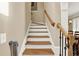 Classic staircase with hardwood steps, white risers, and a natural wood banister at 117 Manous Dr, Canton, GA 30115