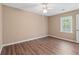 An empty bedroom featuring hardwood floors, ample natural light, and a ceiling fan at 223 Chads Ford Way, Roswell, GA 30076