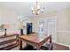Dining area features hardwood floors, a classic chandelier, and a view of the kitchen at 223 Chads Ford Way, Roswell, GA 30076