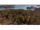 Aerial view of a property surrounded by lush trees, with a glimpse of a lake nearby at 3235 Crestview Dr, Cumming, GA 30041