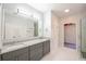 Bright bathroom featuring a double sink vanity with granite countertop and a large mirror with modern lighting at 3235 Crestview Dr, Cumming, GA 30041