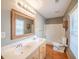 A bathroom with a double sink vanity, framed mirror, bath and shower combo, and wood floors at 3235 Crestview Dr, Cumming, GA 30041