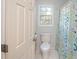 Clean bathroom featuring toilet, window and shower with colorful curtain at 3235 Crestview Dr, Cumming, GA 30041