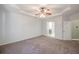 Spacious bedroom with tray ceiling, ceiling fan, and carpet flooring, showcasing an open doorway at 3235 Crestview Dr, Cumming, GA 30041