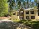 Charming home featuring a stone facade, light yellow stucco, and a well-maintained front yard at 3235 Crestview Dr, Cumming, GA 30041