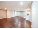 Spacious living area with dark wood-look flooring, neutral walls, and a partial view of the kitchen at 3235 Crestview Dr, Cumming, GA 30041