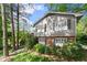 Up close exterior view of the home's two story siding and brick facade, showing window shutters and lush foliage at 4044 Ashentree Dr, Brookhaven, GA 30341
