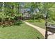 Exterior view of a home with lush greenery and a stone walkway, framed by mature trees on a well-manicured lawn at 4044 Ashentree Dr, Brookhaven, GA 30341