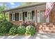 Inviting front porch featuring rocking chairs, brick facade, and a glimpse of the front door with an American flag at 4044 Ashentree Dr, Brookhaven, GA 30341