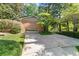 Home exterior featuring a brick facade, attached garage, and long concrete driveway at 4044 Ashentree Dr, Brookhaven, GA 30341