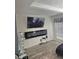 This modern living space features hardwood flooring and a wall-mounted fireplace and television at 6433 Stone Way, Morrow, GA 30260