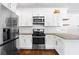 Contemporary kitchen features stainless steel appliances, white cabinets and hardwood floors at 756 Ormewood Se Ave, Atlanta, GA 30312