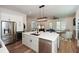 Modern open kitchen boasts stainless steel appliances, island with seating, and beautiful hardwood floors at 2235 Birchtree Way, Marietta, GA 30062