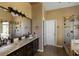 Modern bathroom featuring double vanity with granite countertop, walk-in shower with glass door, and wood-look tile flooring at 2340 Bexford Vw, Cumming, GA 30041