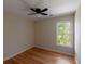 Cozy bedroom featuring hardwood floors, a ceiling fan with light, and a window with a view of trees at 2340 Bexford Vw, Cumming, GA 30041