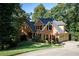 Beautiful brick two-story home featuring a well-manicured lawn, mature trees, and a driveway leading to the garage at 2340 Bexford Vw, Cumming, GA 30041