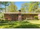Expansive backyard with well-manicured lawn, brick facade, and mature shade trees at 2927 Ponderosa Cir, Decatur, GA 30033