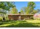 Spacious backyard with well-maintained lawn, brick facade, and mature trees provides privacy at 2927 Ponderosa Cir, Decatur, GA 30033