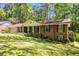 Classic brick home with a welcoming front porch, lush greenery, and a convenient attached garage at 2927 Ponderosa Cir, Decatur, GA 30033