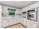 Traditional kitchen featuring white cabinetry, stainless steel oven, and a window over the sink at 2927 Ponderosa Cir, Decatur, GA 30033